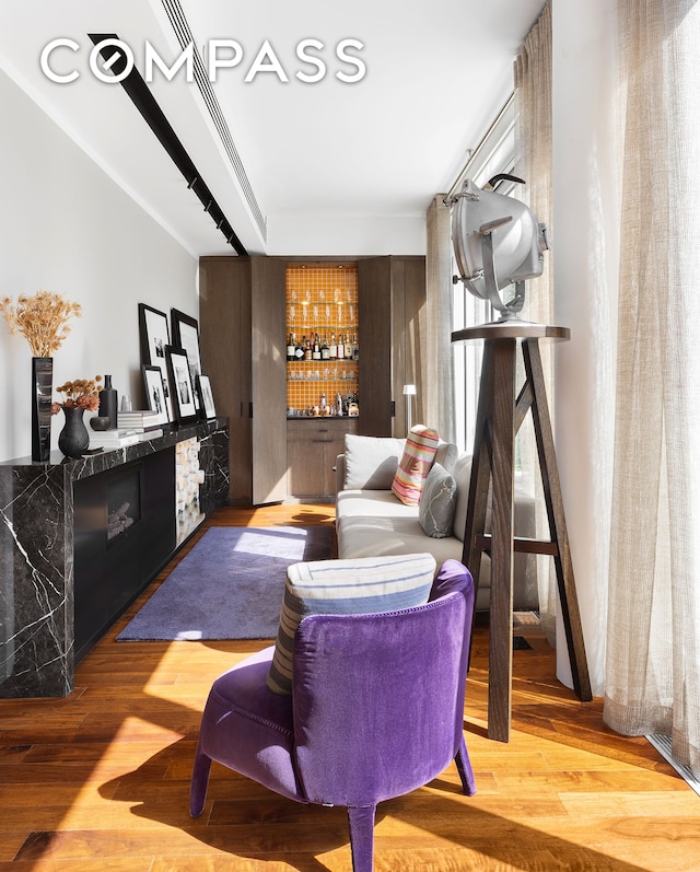 interior space featuring a bar, a fireplace, and wood finished floors