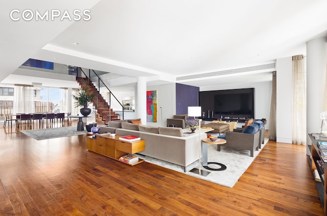 living room with stairway and wood finished floors