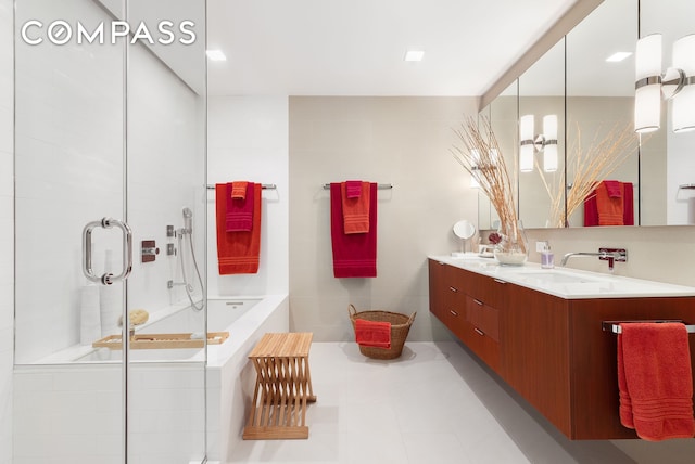 bathroom with double vanity, a garden tub, a sink, and a stall shower