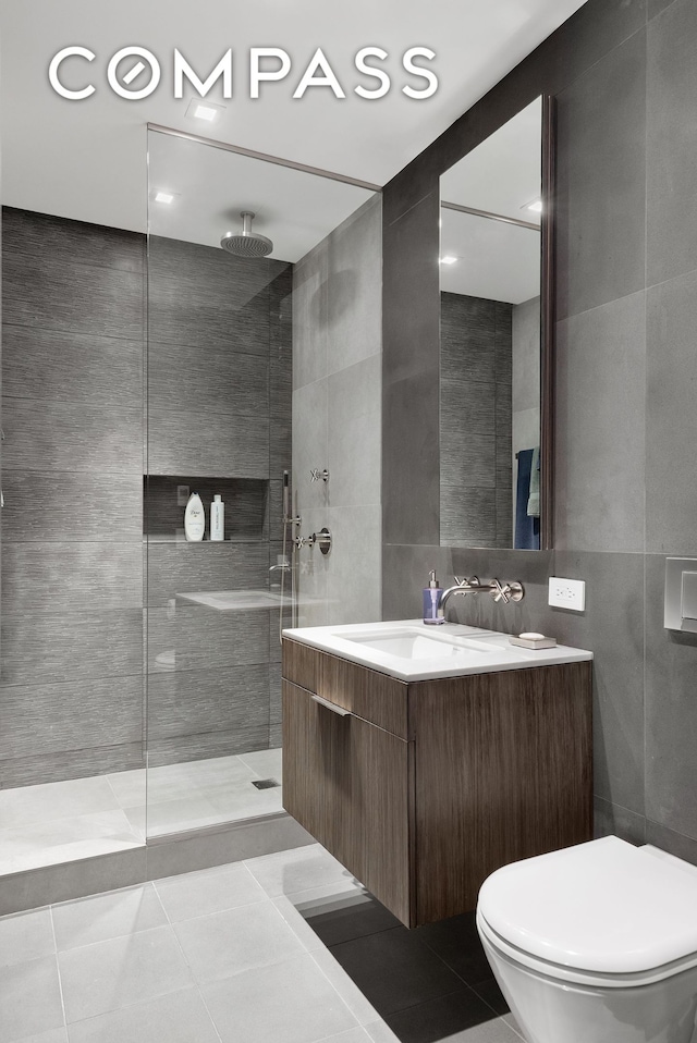 bathroom featuring a sink, walk in shower, tile walls, and tile patterned floors