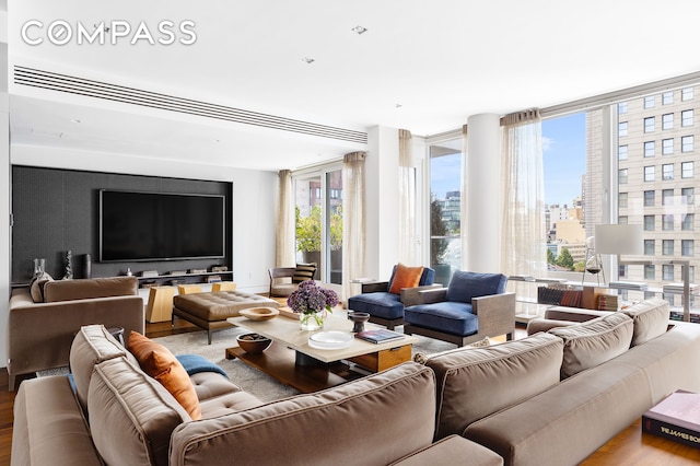 living room with expansive windows and wood finished floors