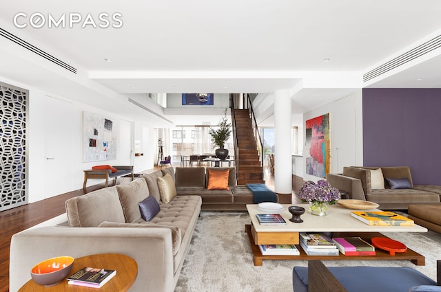 living area featuring stairs, wood finished floors, and visible vents