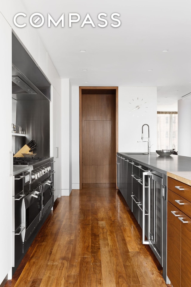 kitchen featuring dark wood-style floors, modern cabinets, wine cooler, and a sink