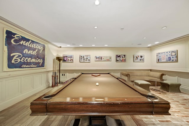 game room with crown molding, a decorative wall, wood finished floors, and recessed lighting