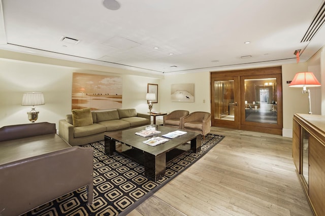 living room with light wood-type flooring and french doors