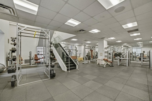 gym with a paneled ceiling and visible vents