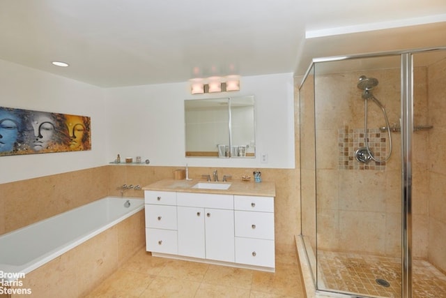 bathroom featuring plus walk in shower, vanity, and tile patterned flooring