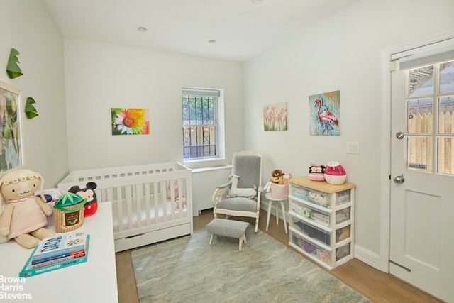 bedroom with a crib and hardwood / wood-style floors