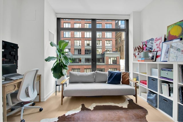 sitting room with floor to ceiling windows and light hardwood / wood-style floors