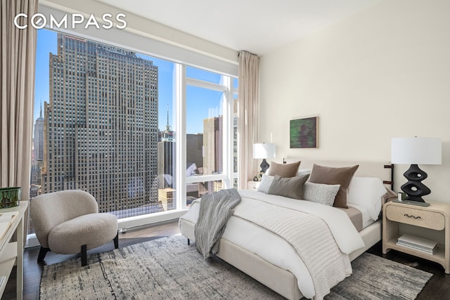 bedroom featuring a view of city and wood finished floors