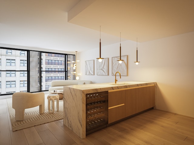 bar with light wood-style floors, wine cooler, and a sink