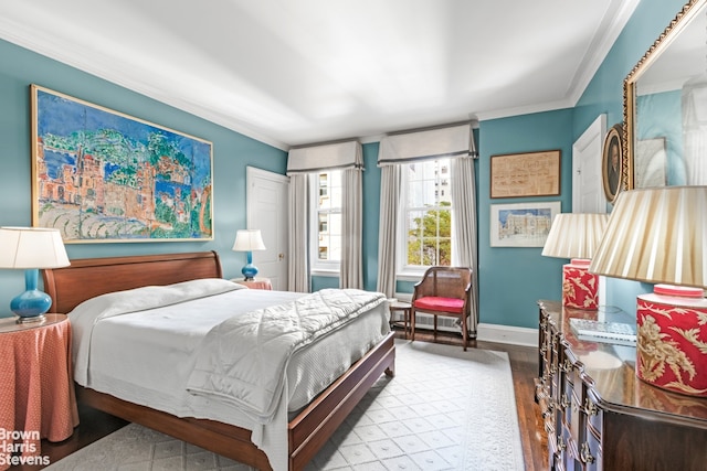 bedroom featuring wood finished floors, baseboards, and ornamental molding