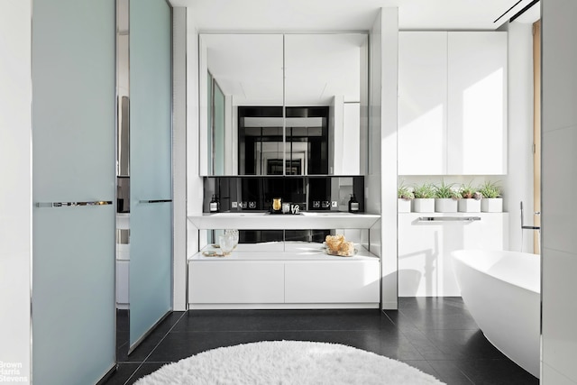 full bath featuring a soaking tub, vanity, and tile patterned flooring