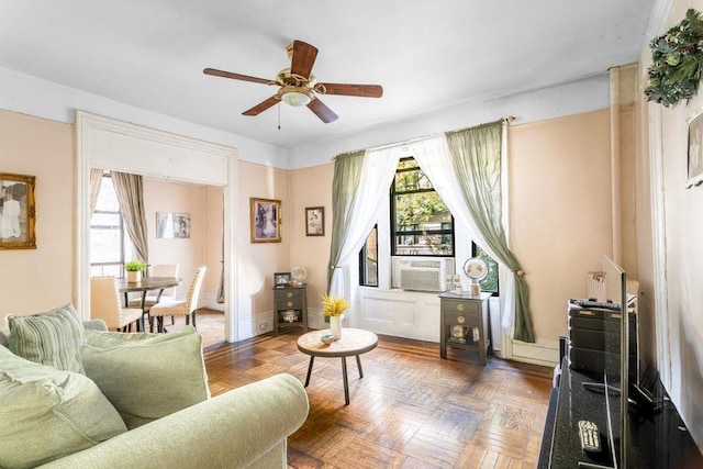 living area featuring ceiling fan, cooling unit, and dark parquet floors