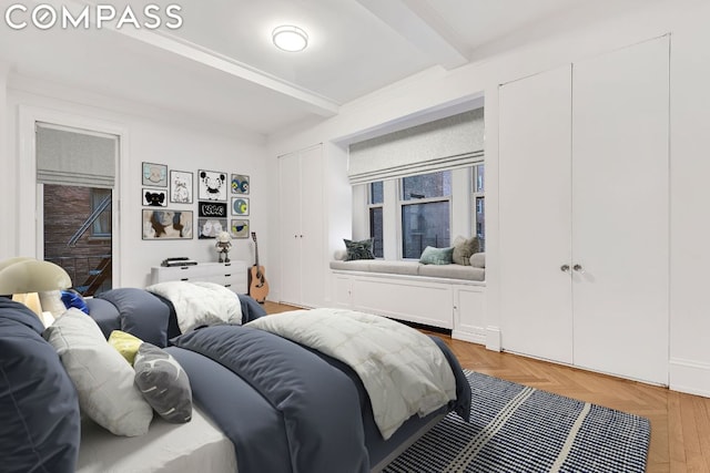 bedroom featuring parquet floors and beamed ceiling