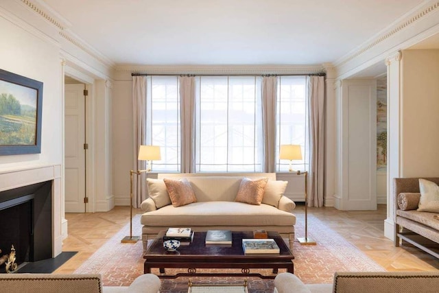 living area with crown molding, plenty of natural light, and a fireplace with flush hearth