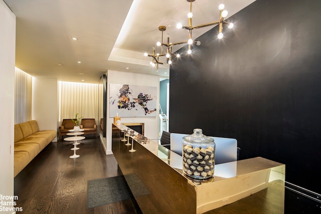 interior space with an inviting chandelier, a fireplace, and wood finished floors