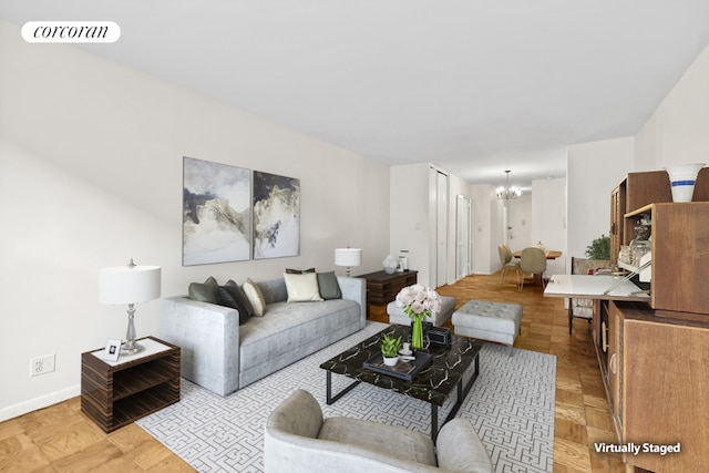 living area featuring visible vents, a notable chandelier, and baseboards