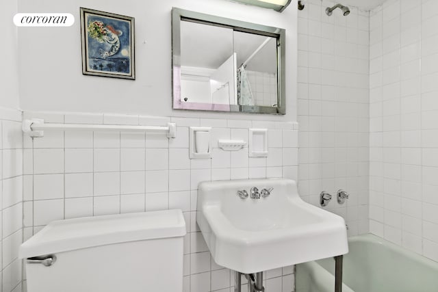 full bath featuring visible vents, a sink, shower / bath combo with shower curtain, tile walls, and toilet