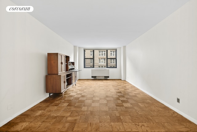 unfurnished living room with radiator, baseboards, and visible vents