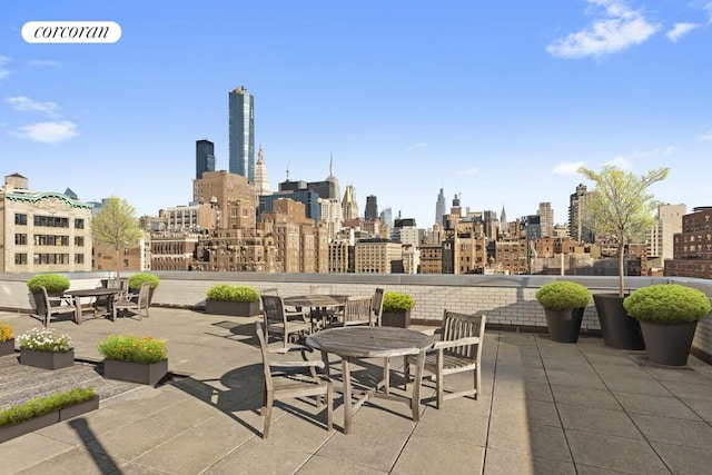 view of patio featuring outdoor dining space and a view of city