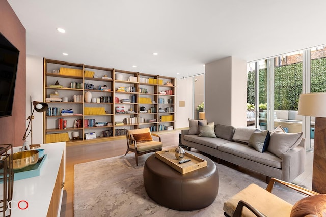 sitting room with floor to ceiling windows, recessed lighting, and wood finished floors