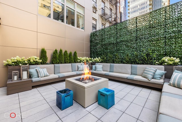 view of patio with an outdoor living space with a fire pit