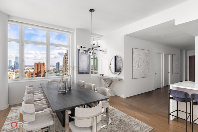 dining area with a city view, baseboards, dark wood-type flooring, and an inviting chandelier