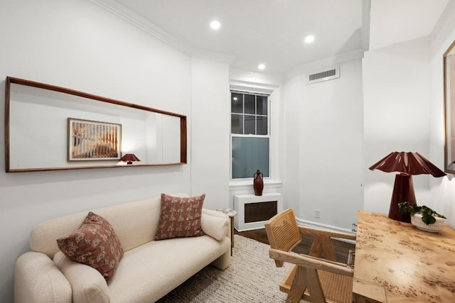 sitting room featuring wood-type flooring and ornamental molding