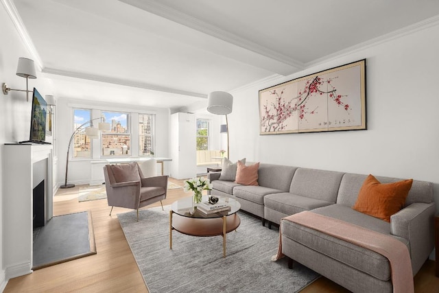 living room featuring light hardwood / wood-style flooring, ornamental molding, and beamed ceiling