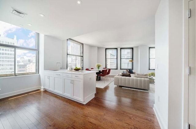 kitchen with white cabinetry, dark hardwood / wood-style floors, sink, and kitchen peninsula