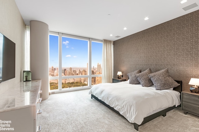 carpeted bedroom featuring expansive windows and multiple windows