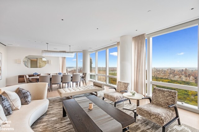 bedroom featuring floor to ceiling windows, light colored carpet, and multiple windows