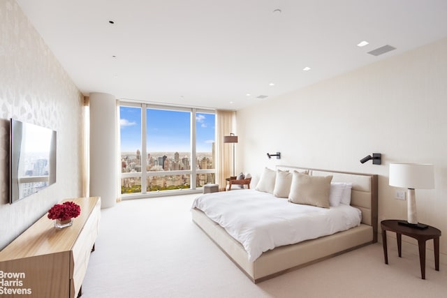 bedroom featuring expansive windows and light colored carpet