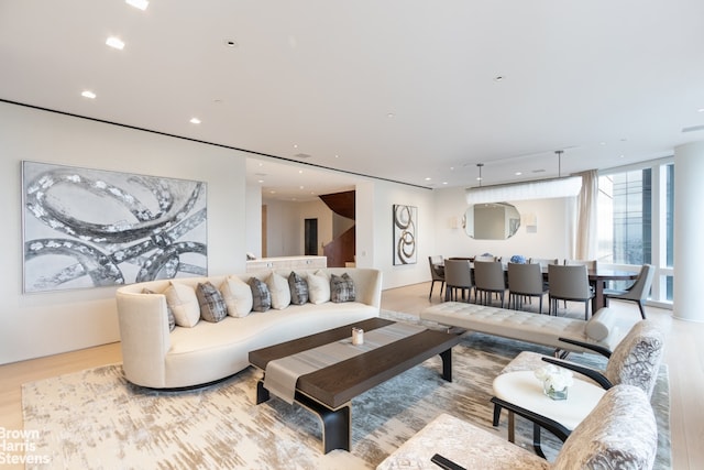 living room with expansive windows and light hardwood / wood-style floors