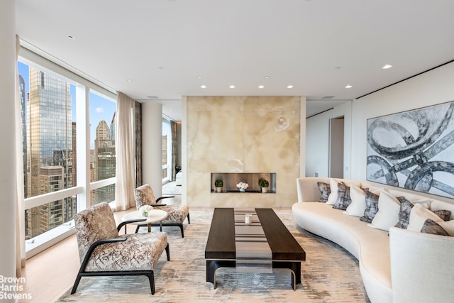 living room featuring a wall of windows and light hardwood / wood-style flooring