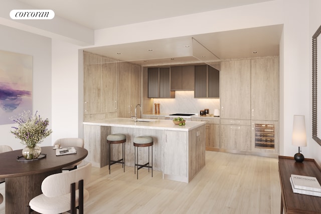 kitchen featuring sink, backsplash, black gas cooktop, kitchen peninsula, and light wood-type flooring