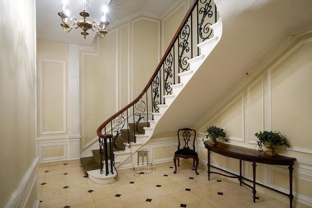 stairway featuring crown molding, a notable chandelier, and tile patterned floors