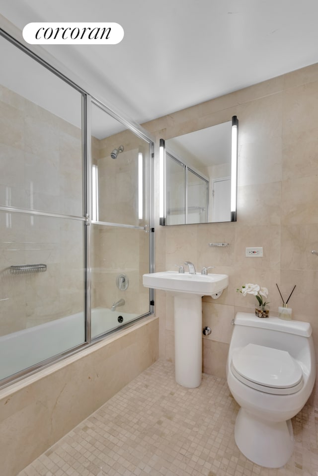205 E 63rd St Unit 6A, New York City, NY 10065 - full bathroom featuring tile walls, toilet, tiled shower / bath, and tile patterned flooring