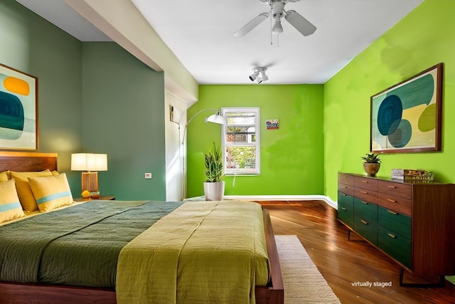 bedroom featuring a ceiling fan, baseboards, and dark wood-style flooring