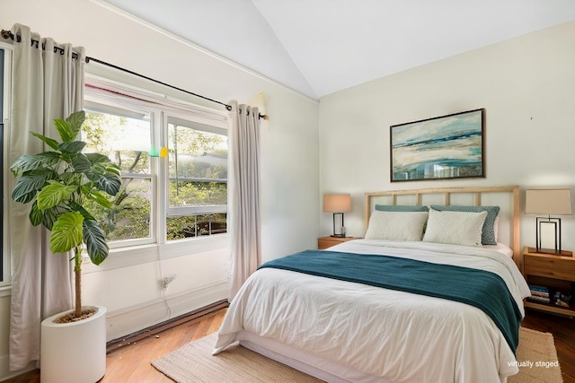 bedroom featuring lofted ceiling and wood finished floors