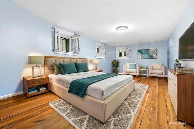 bedroom with baseboards and wood finished floors