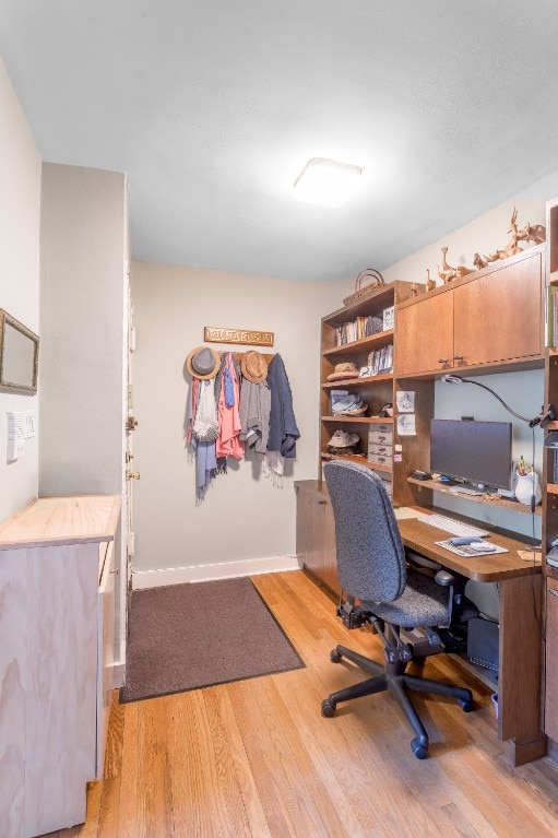 office area featuring light wood-type flooring and baseboards