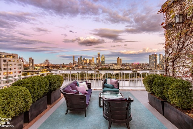 view of patio featuring a view of city, a water view, a balcony, and an outdoor living space