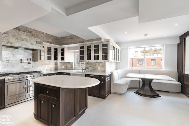 60 Sutton Pl S Unit Ph19S, New York City, NY 10022 - kitchen featuring range with two ovens, light countertops, a sink, glass insert cabinets, and recessed lighting