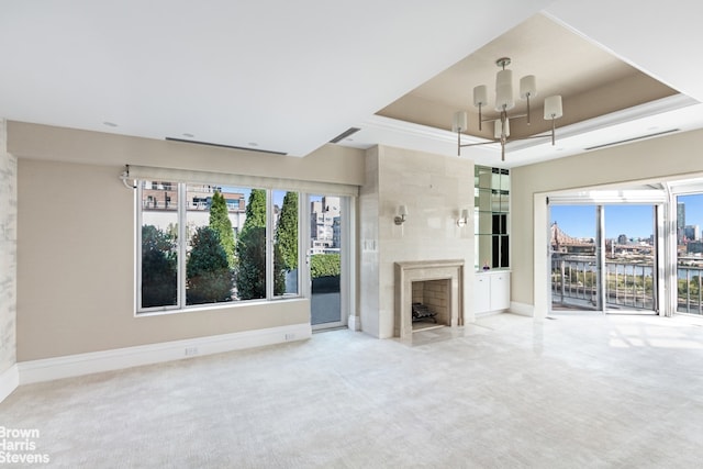 60 Sutton Pl S Unit Ph19S, New York City, NY 10022 - unfurnished living room featuring a chandelier, carpet flooring, a raised ceiling, and a high end fireplace