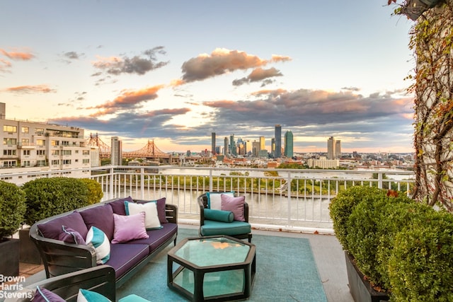 patio terrace at dusk with a water view, a balcony, and an outdoor hangout area