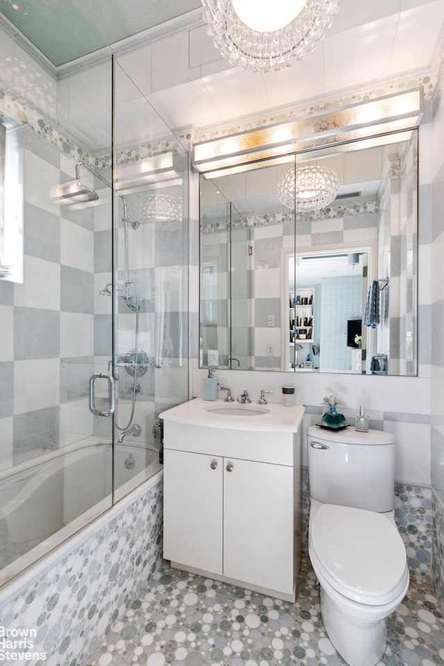 60 Sutton Pl S Unit Ph19S, New York City, NY 10022 - bathroom featuring shower / bath combination with glass door, vanity, toilet, tile walls, and tile patterned flooring