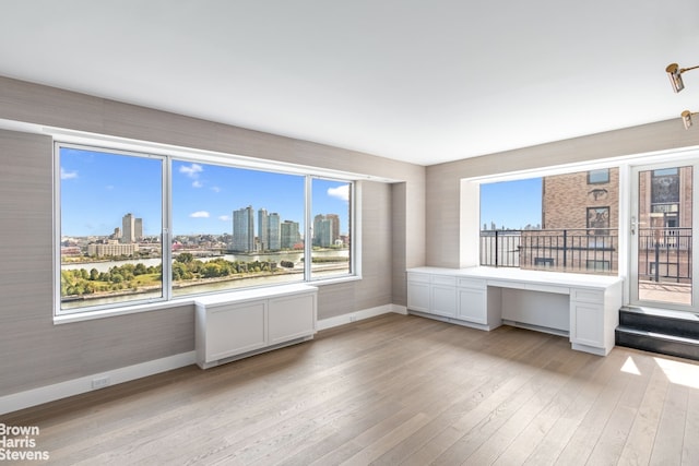 60 Sutton Pl S Unit Ph19S, New York City, NY 10022 - unfurnished room featuring baseboards, light wood-style floors, and a view of skyline