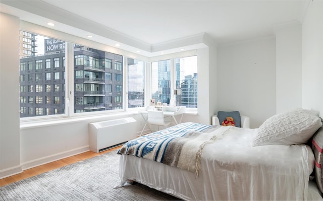 bedroom with crown molding, baseboards, wood finished floors, and recessed lighting